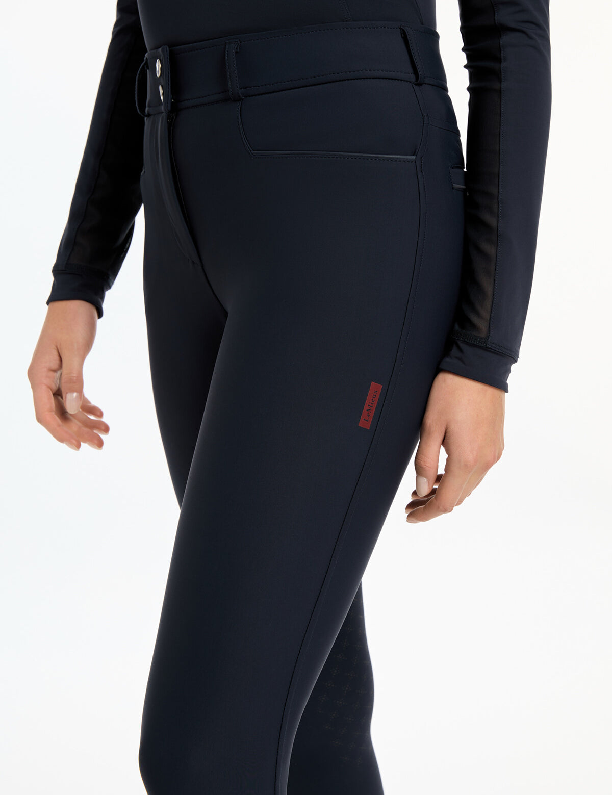 Close-up side view of a model wearing the navy LeMieux Isabelle Knee Grip Breeches on a white background