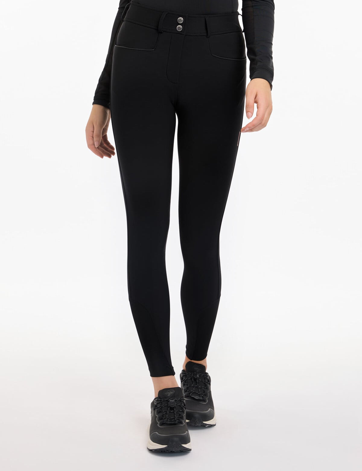 Front view of a model wearing the black LeMieux Isabelle Knee Grip Breeches on a white background