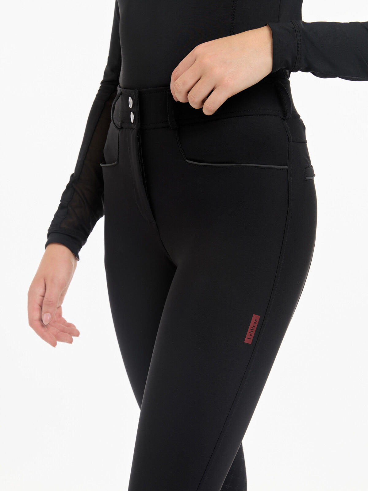 Angled front view of a model wearing the black LeMieux Isabelle Knee Grip Breeches on a white background