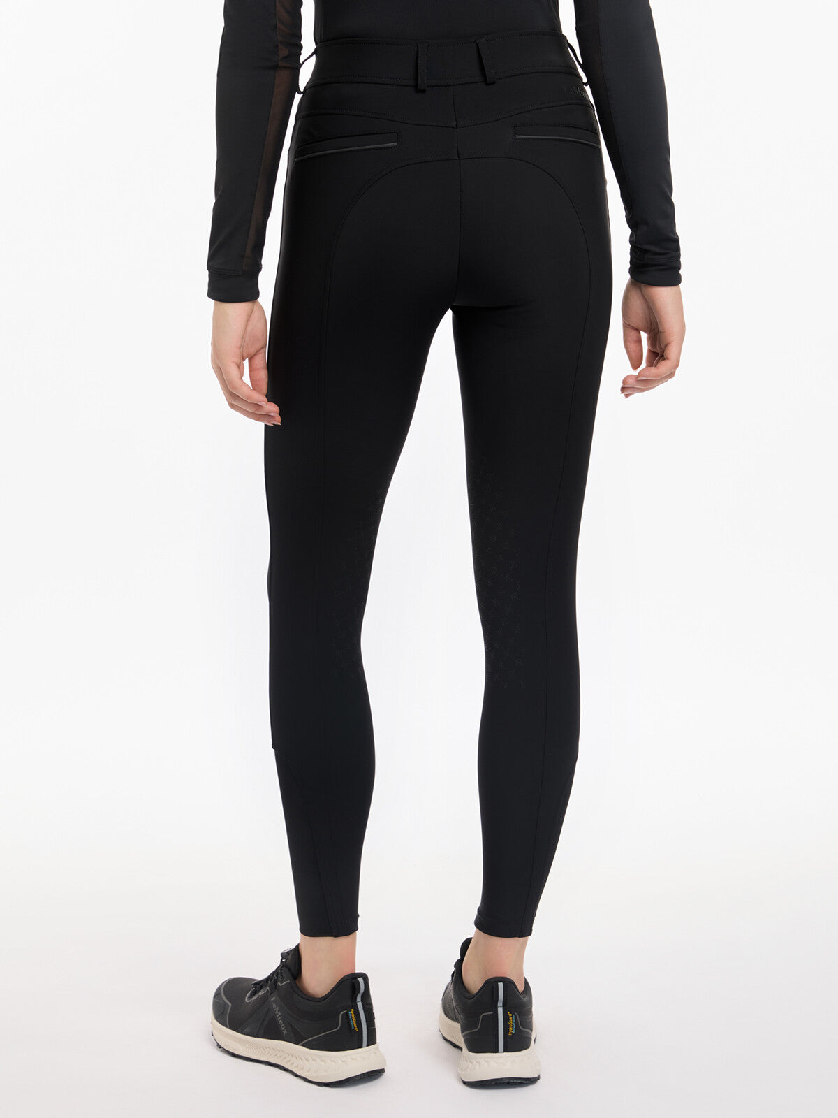 Back view of a model wearing the black LeMieux Isabelle Knee Grip Breeches on a white background