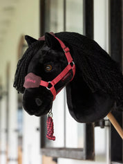 Side view of the Spike black LeMieux Hobby Horse in a barn aisle