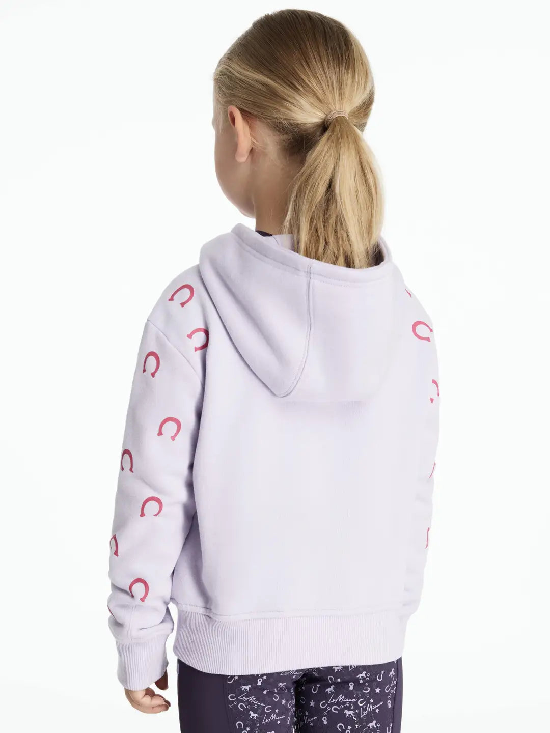Back view of a young child wearing the purple LeMieux Mini Romie Hoody on a white background