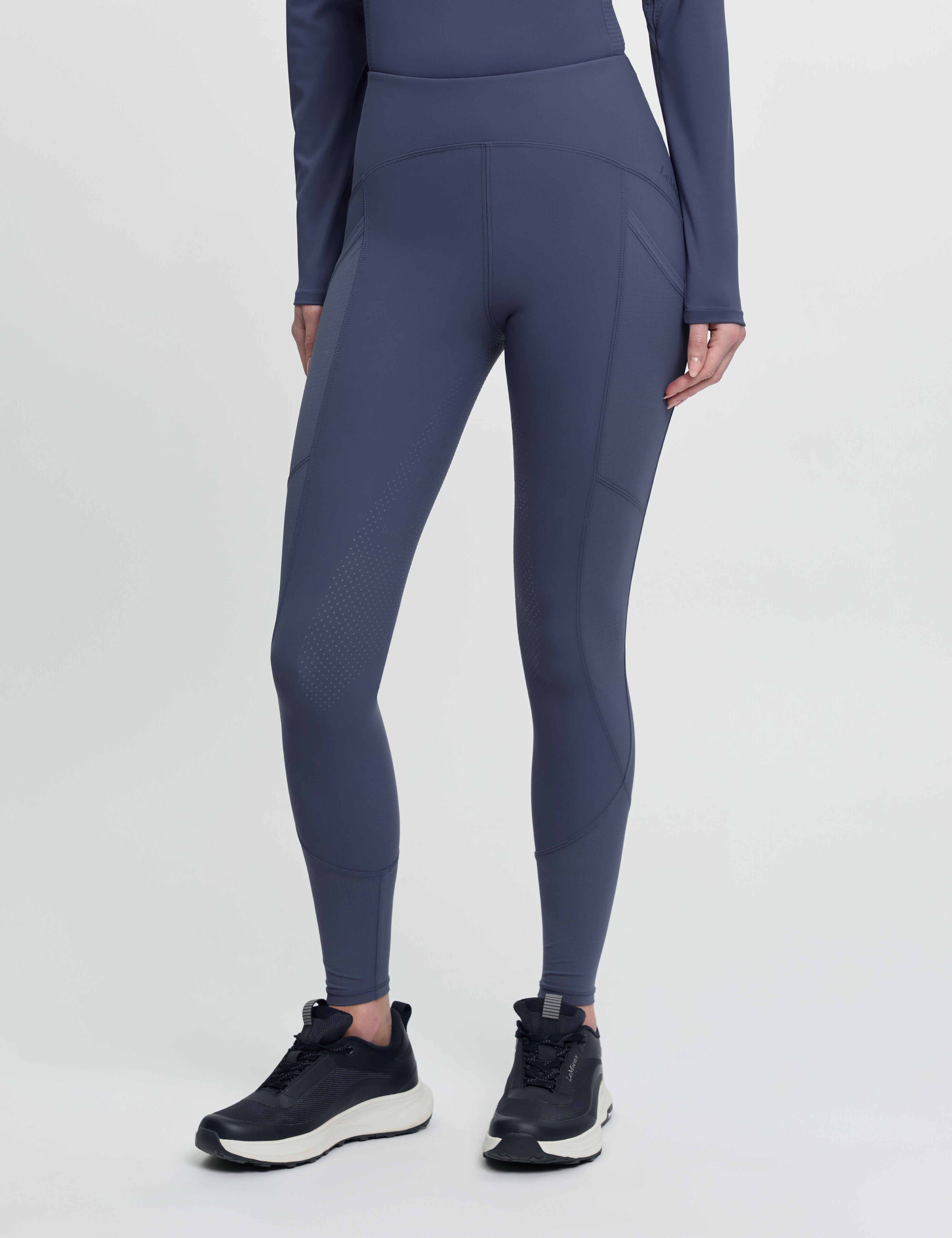 Front view of a model wearing the blue LeMieux Airflow Full Seat Pull On Breeches on a plain background