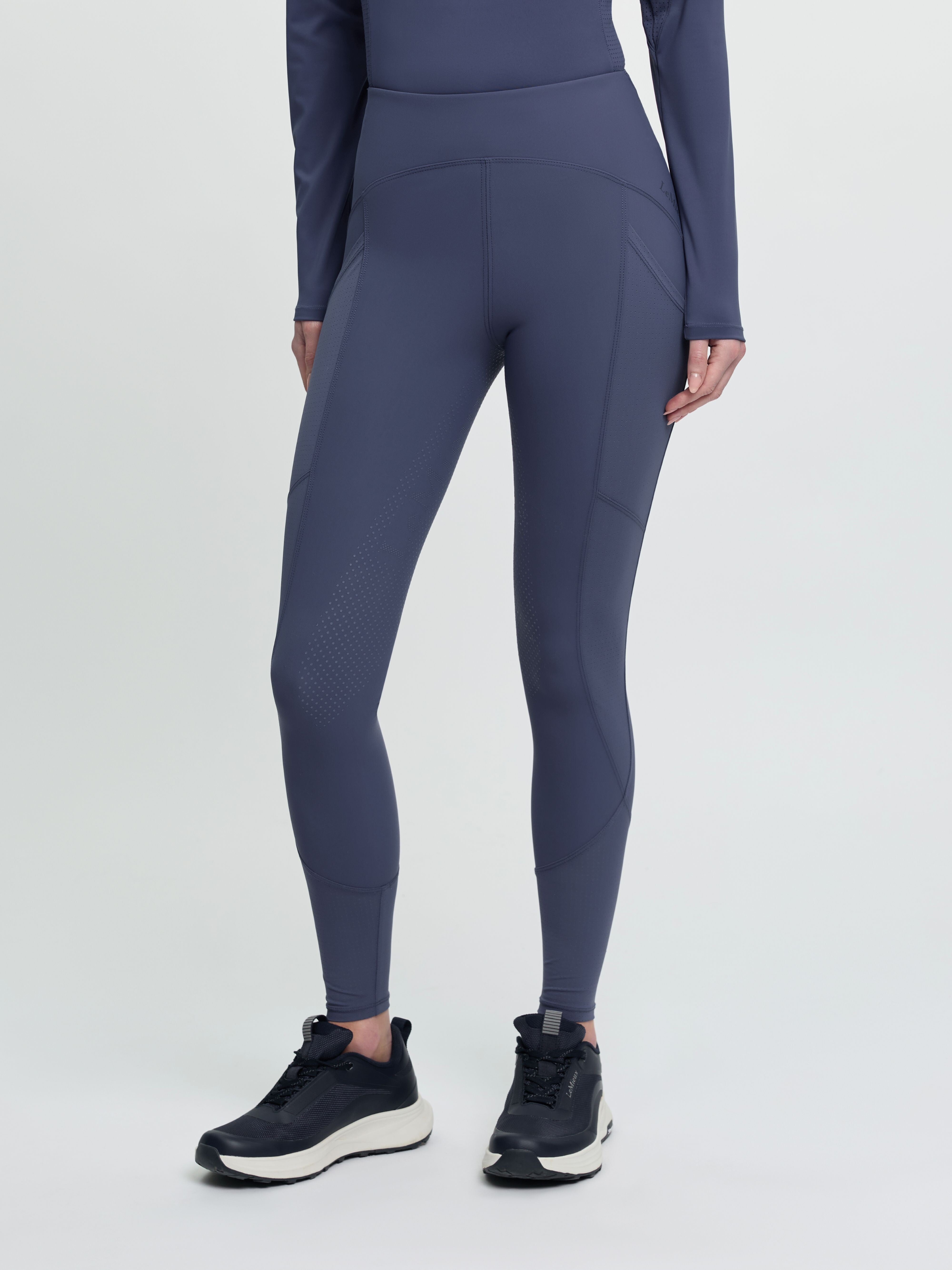 Front view of a model wearing the blue LeMieux Airflow Full Seat Pull On Breeches on a plain background