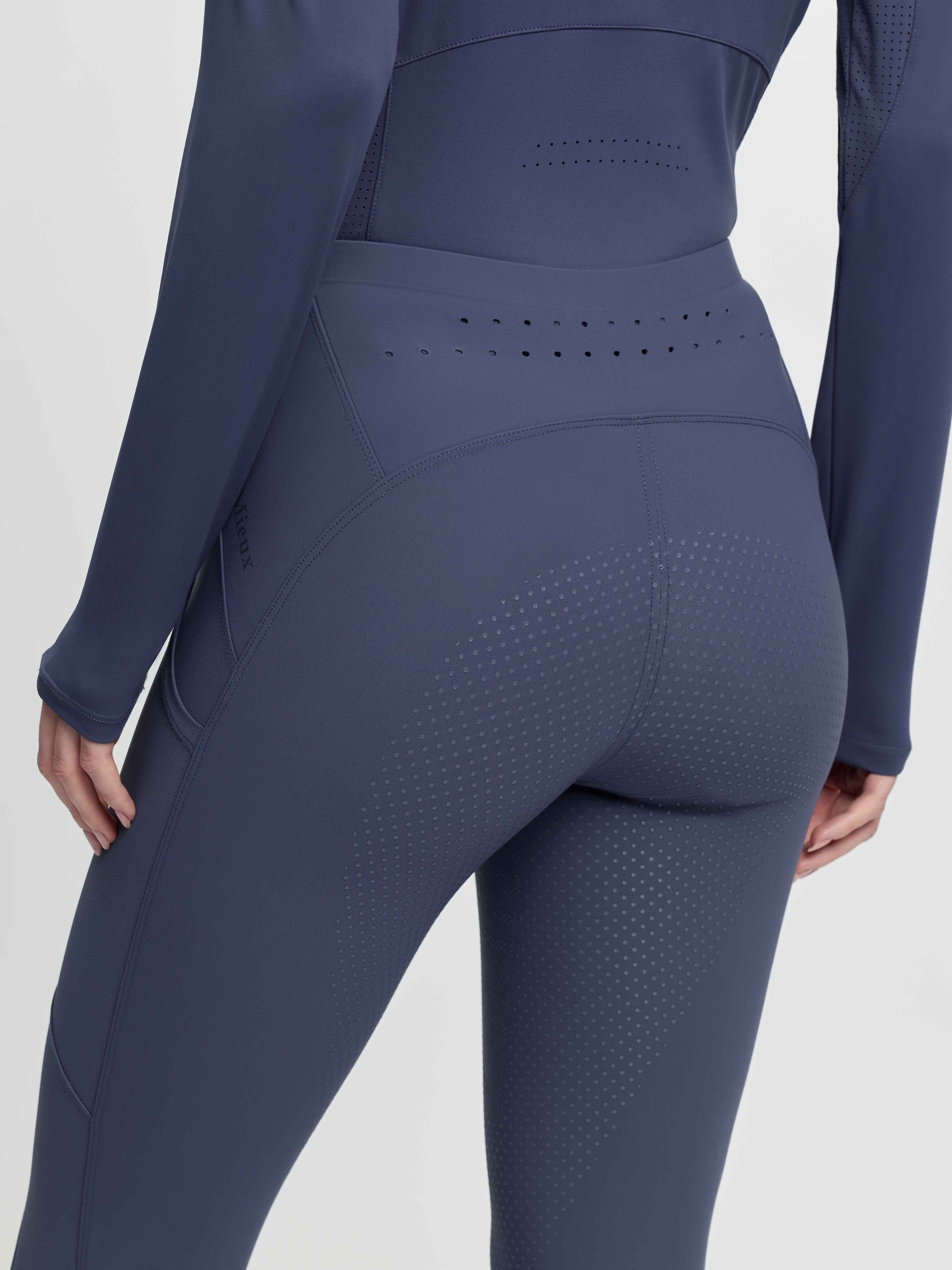 Close-up back view of a model wearing the blue LeMieux Airflow Full Seat Pull On Breeches on a plain background
