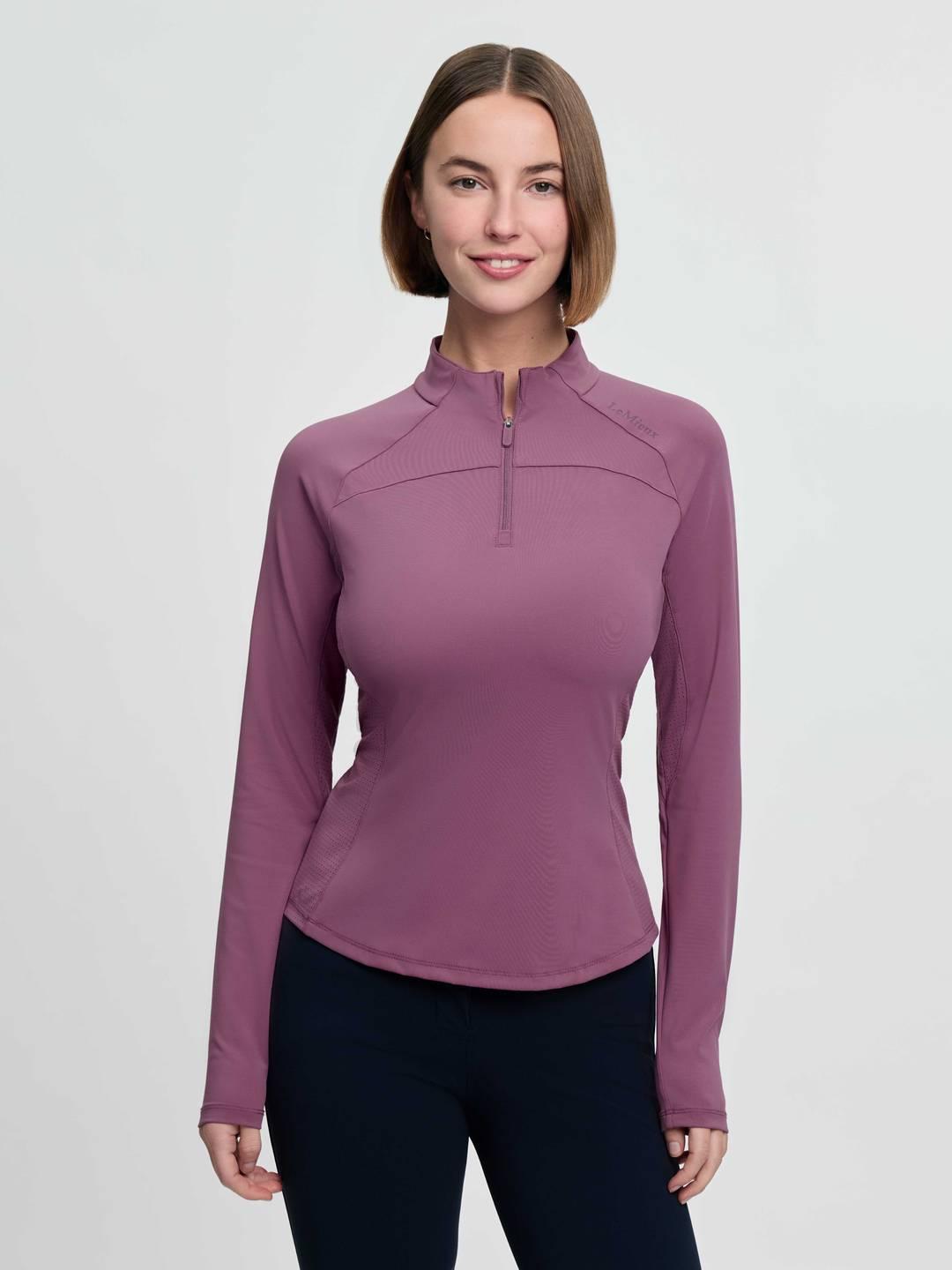 Front view of a female model wearing the purple LeMieux Airflow Long Sleeve Base Layer on a plain background