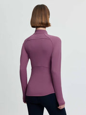 Back view of a female model wearing the purple LeMieux Airflow Long Sleeve Base Layer on a plain background
