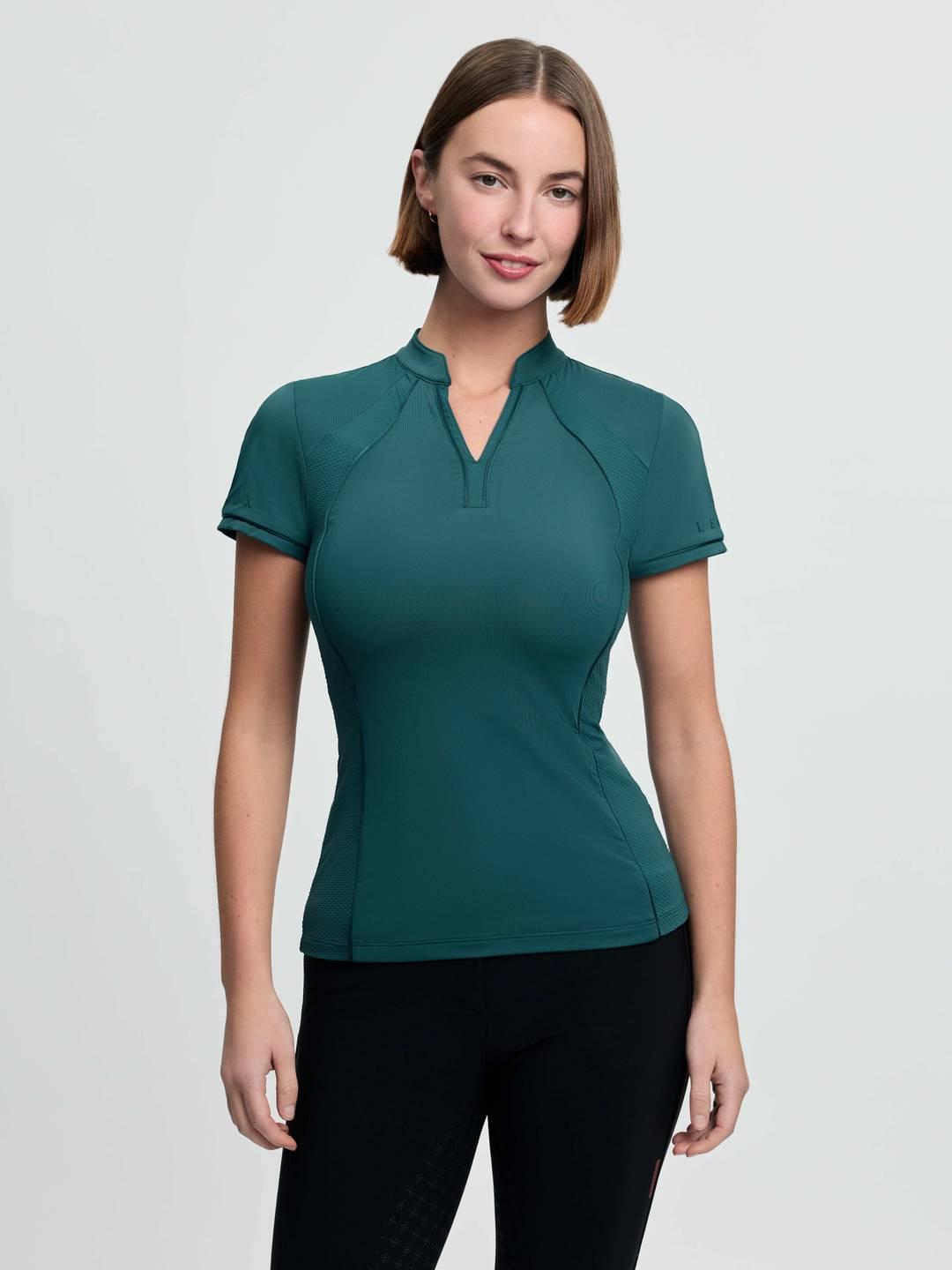 Front view of a female model wearing the green LeMieux Lisa Mesh Short Sleeve Base Layer on a plain background