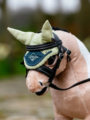 Angled front view of a buckskin toy pony wearing the green LeMieux Toy Pony Fly Hood