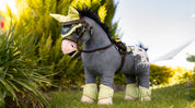 Angled front view of a gray appaloosa wearing the green LeMieux Toy Pony Fly Hood and matching set while standing in the grass