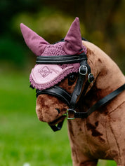 Close-up angled front view of a brown toy pony wearing the pink LeMieux Toy Pony Fly Hood