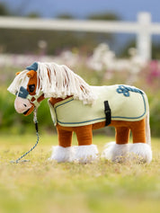 Green and blue toy fleece cooler on a palomino stuffed animal horse standing outside