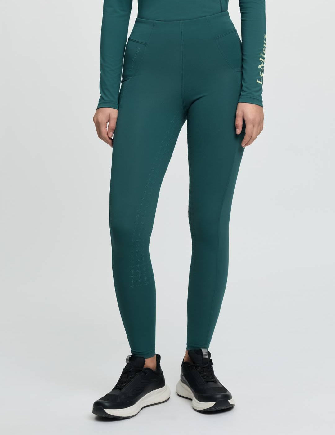 Front view of a model wearing the jungle Lemieux Young Rider Orla Pull On Tight on a plain background