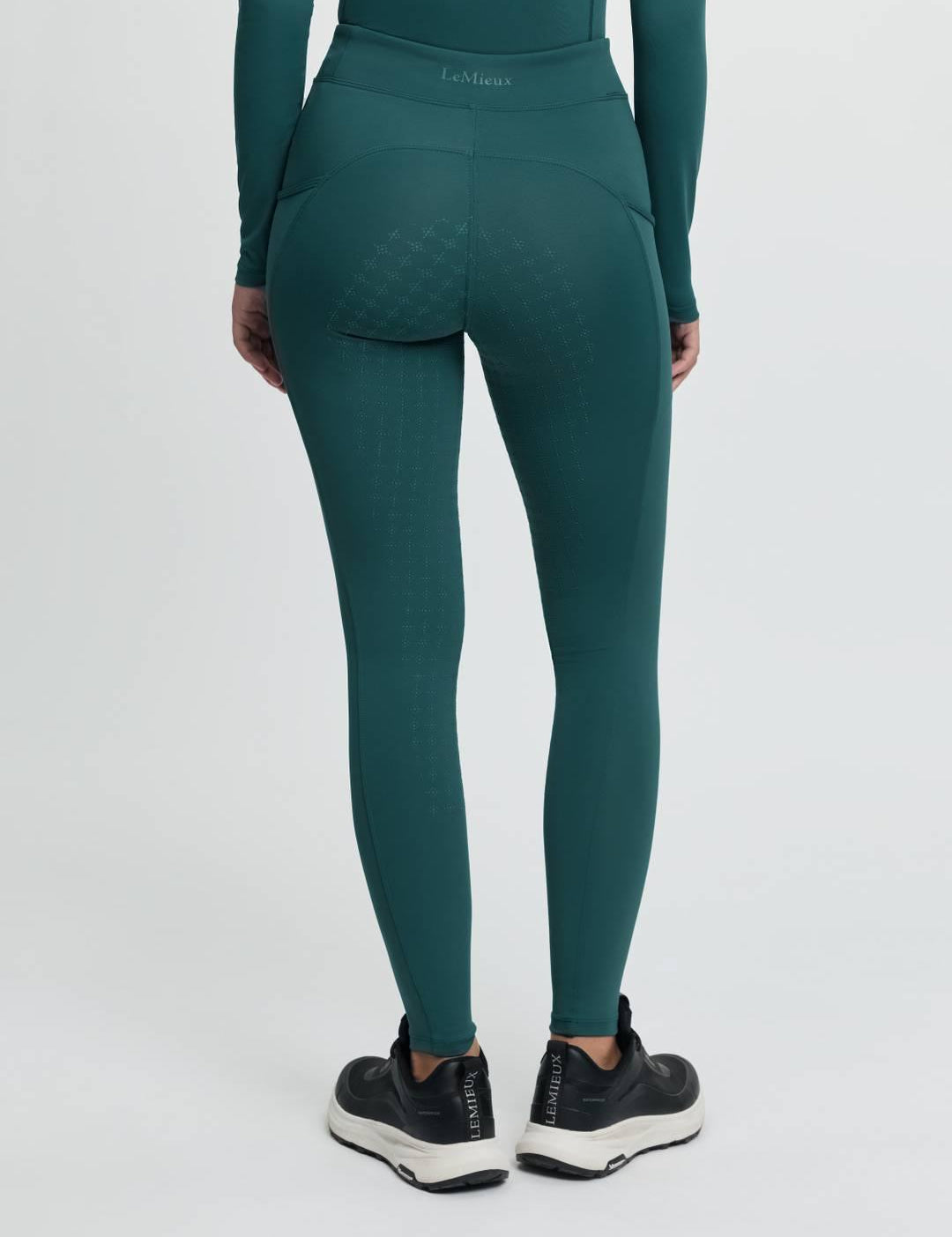 Back view of a model wearing the jungle Lemieux Young Rider Orla Pull On Tight on a plain background