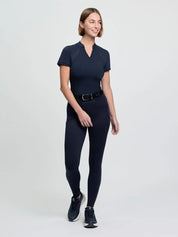 Model wearing LeMieux Cami Sculpt Full Seat Breeches in navy with short sleeve top and black athletic shoes