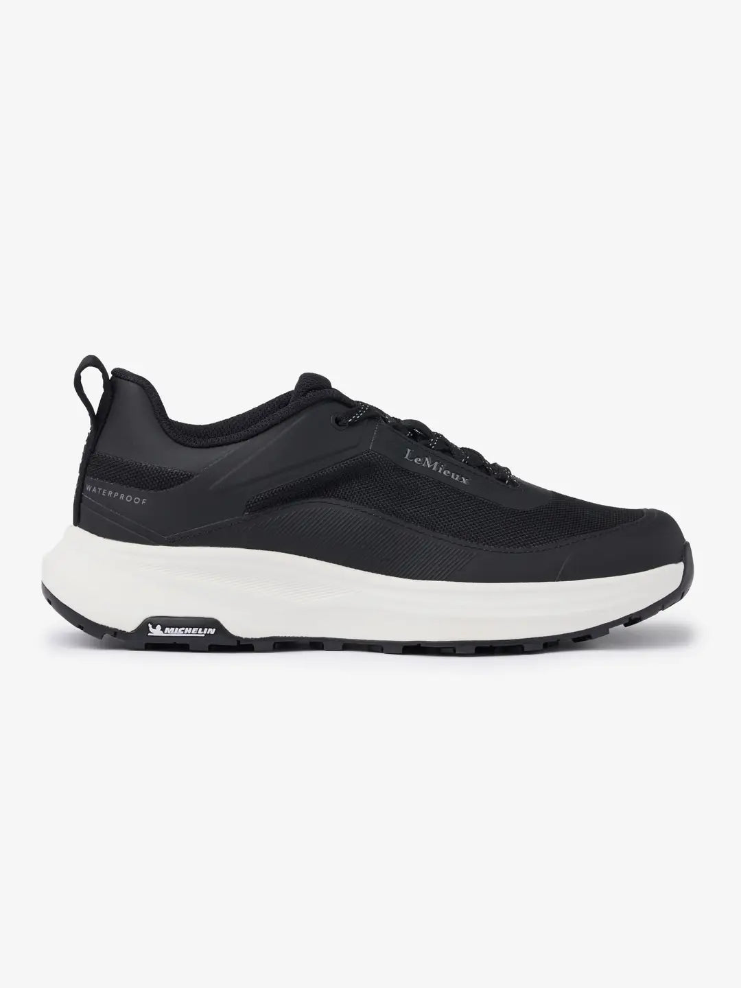 Side view of the black LeMieux Kanta Waterproof Trainer on a white background
