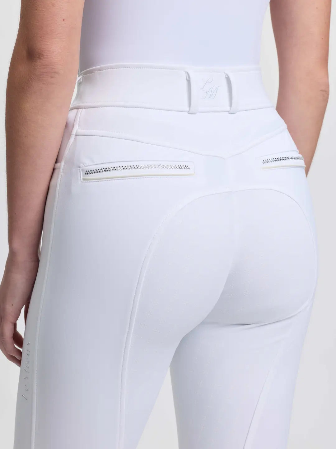 Close-up back view of a model wearing the white LeMieux Brilliance Full Seat Breeches on a plain background