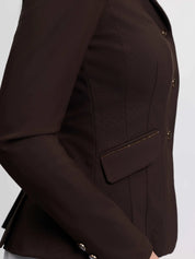 Close-up side view of a model wearing the brown LeMieux Brilliance Diana Show Jacket on a plain background