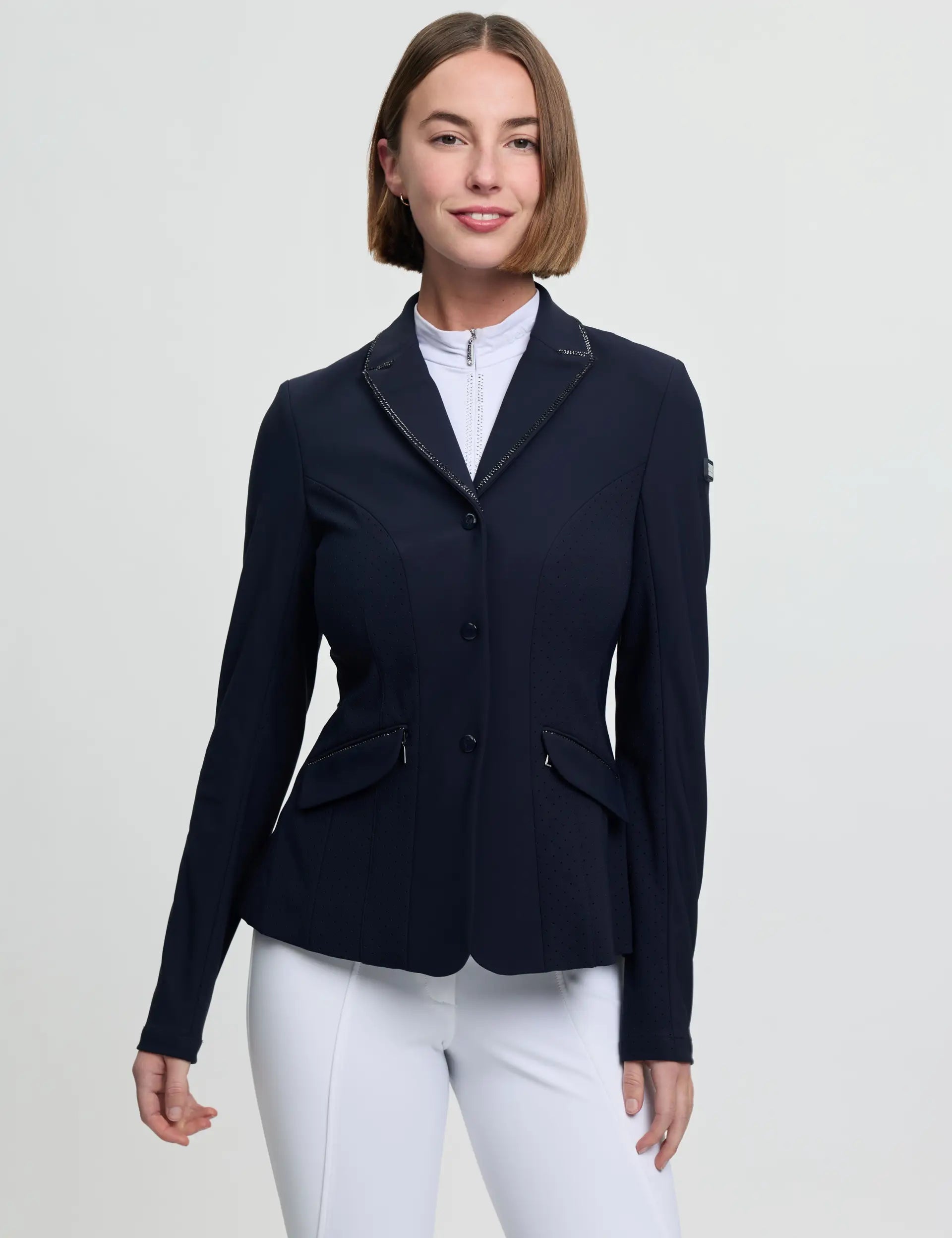 Front view of a female model wearing the navy LeMieux Brilliance Diana Show Jacket on a plain background