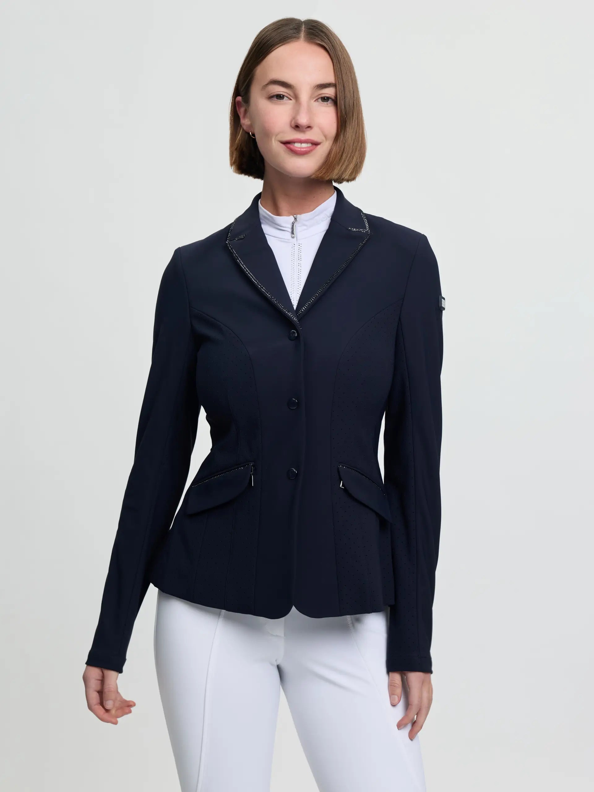 Front view of a female model wearing the navy LeMieux Brilliance Diana Show Jacket on a plain background