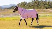 Brown horse trotting in a field wearing the LeMieux Arika Ripstop 0G Turnout Rug in Fondant