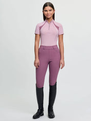 Full body front view of a young female model wearing the pink LeMieux Young Rider Mia Mesh Short Sleeve Base Layer and coordinating tights on a plain backgrounf