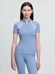Front view of a young female model wearing the blue LeMieux Young Rider Mia Mesh Short Sleeve Base Layer on a plain background