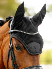 Close-up angled front view of a bay horse wearing the black LeMieux Brilliance Fly Hood
