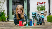 View of a young girl playing with the LeMieux Toy Pony Course Builder Set on a patio outside