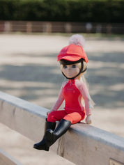 Front view of the coral Harlow LeMieux Toy Rider sitting on a fence