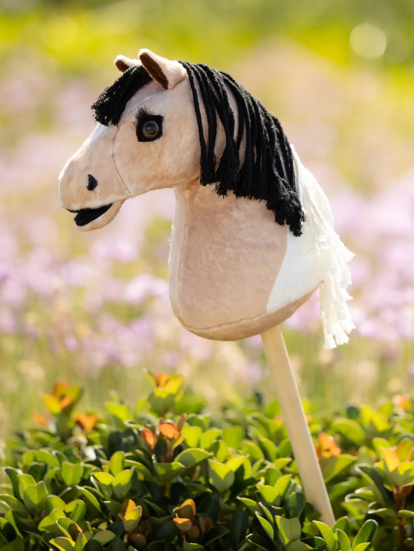 Side view of a LeMieux Mini Hobby Horse in a buckskin paint color outside