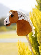 Side view of the LeMieux Mini Hobby Horse in a palomino color with white mane outside