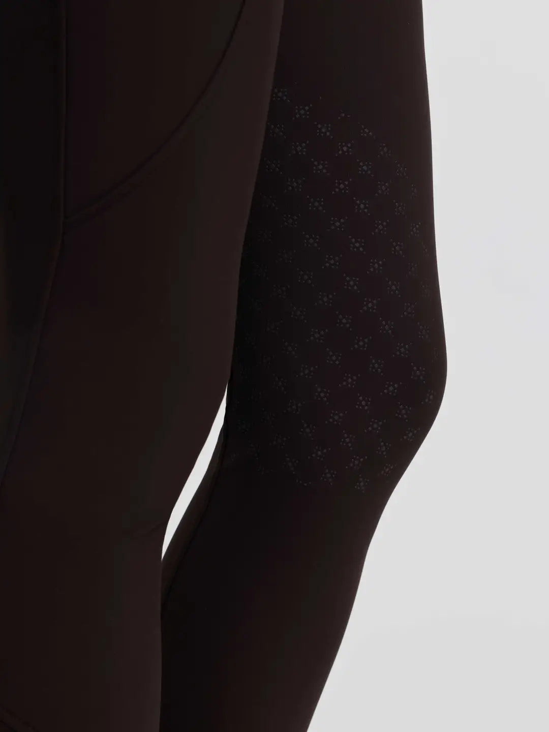 Close-up side view of the silicone grip on the brown LeMieux Brilliance Knee Grip Breeches on a plain background