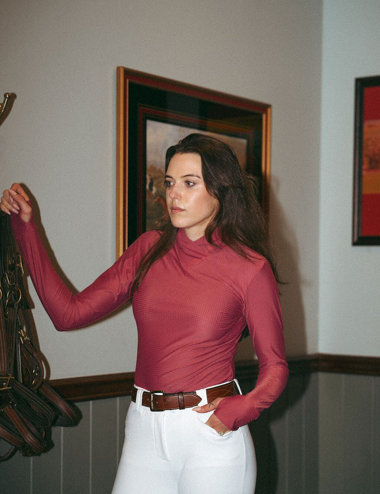 Front view of a female model wearing the cherry blossom Criniere Kai Shirt while standing in a tack room