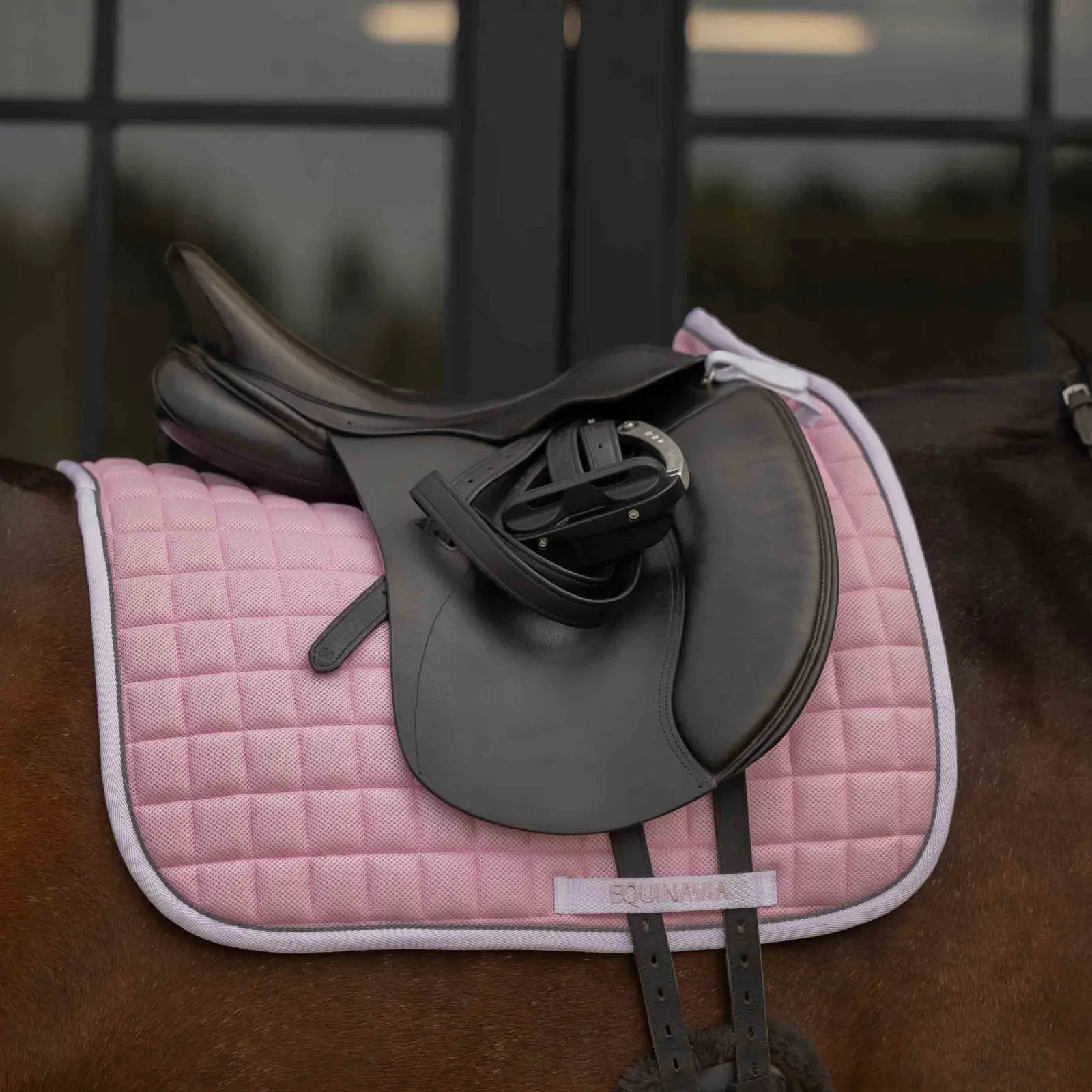 Side view of a bay horse wearing the pink Equinavia Svalbard Dressage Saddle Pad with NordicAir Tech under a saddle