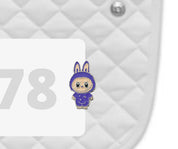Side view of a white pad with numbers 378 and a Labubu Dubois Cheval Number Pin Charm on a white background