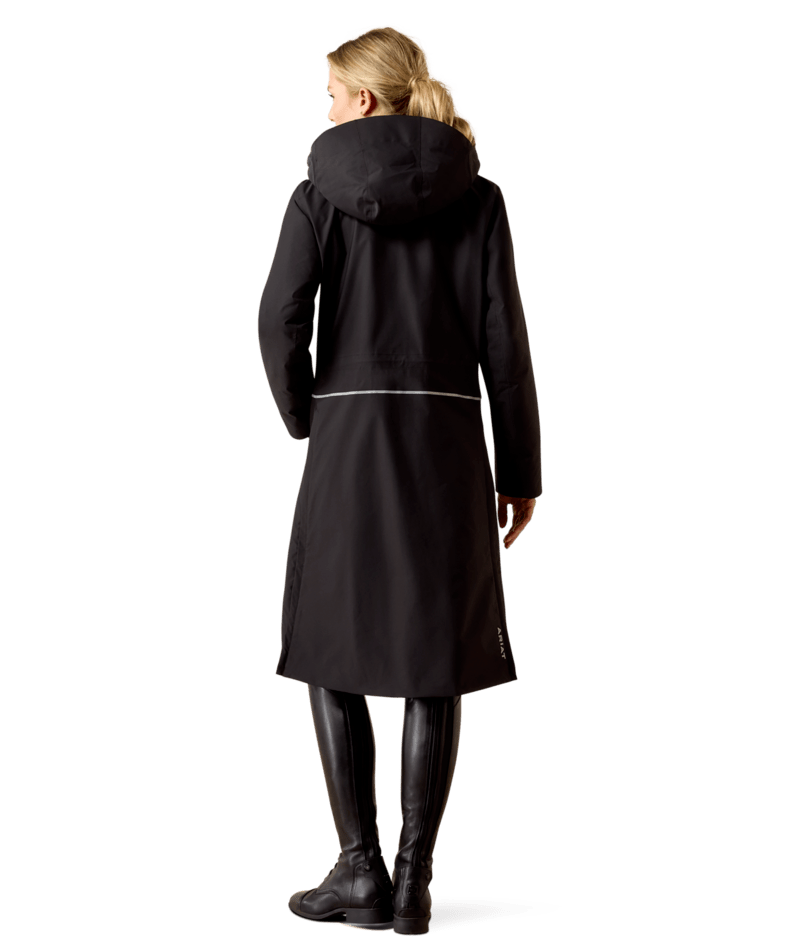 Full body back view of a female model wearing the Black Ariat Long Rider Waterproof Coat on a white background