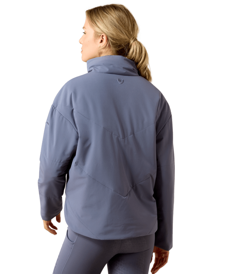 Back view of a female model wearing the Grisaille Ariat Cocoon Insulated Jacket on a white background