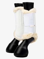 Pair of white LeMieux Fleece Edged Brushing Boots on plastic black horse legs on white background