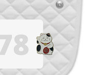 Side view of a white pad with numbers 378 and a Lucky Cat Dubois Cheval Number Pin Charm on a white background