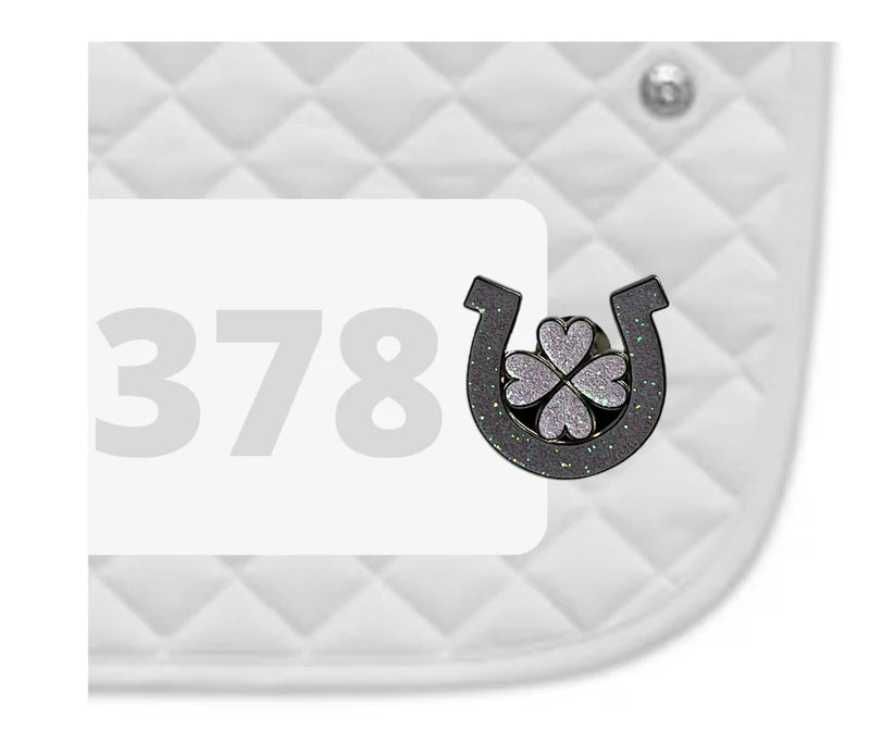 Side view of a white pad with numbers 378 and a Horseshoe Clover Dubois Cheval Number Pin Charm on a white background