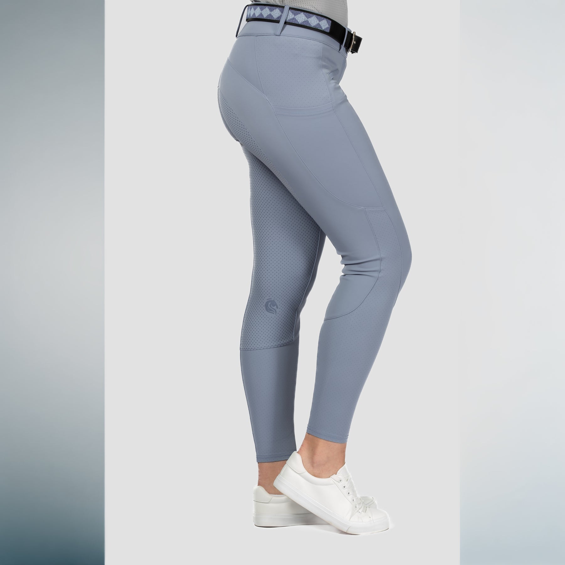 Side view of a model wearing Dusk Blue Equinavia Birgit Summer Full Seat Breeches on a plain background
