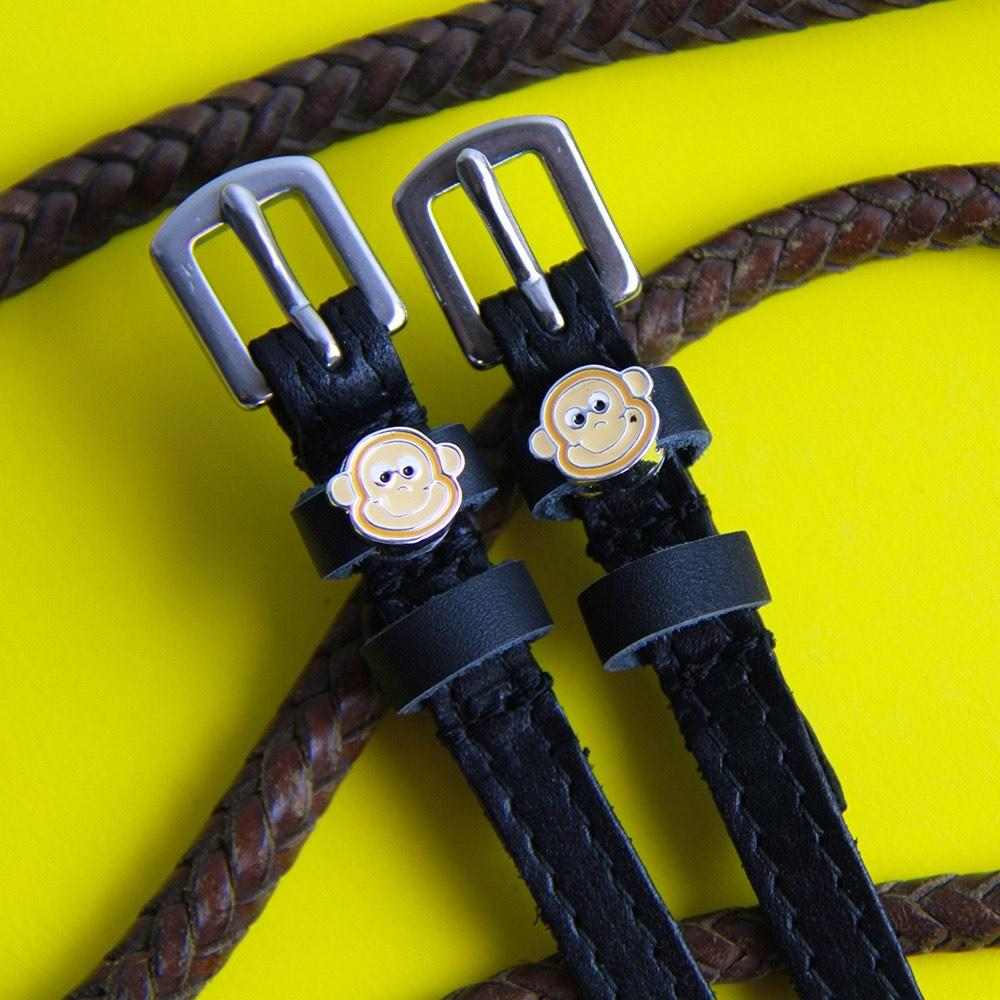 Close-up view of the Monkey Faces Mane Jane Spur Straps on a yellow background