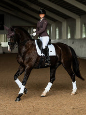 Full view of a female model riding a dark colored horse with a Moonless Night Equestrian Stockholm White Modern Dressage Pad
