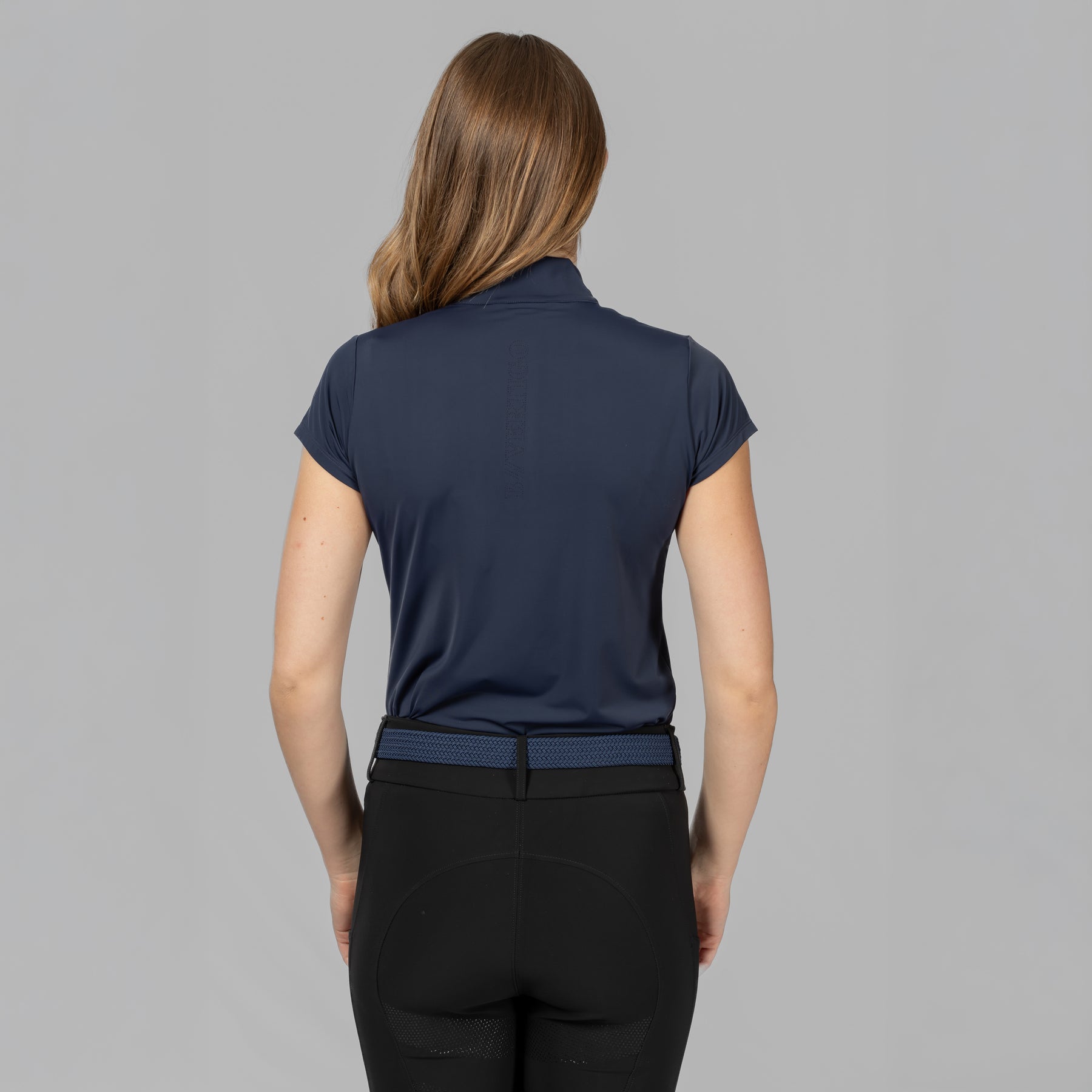 Back view of a female model wearing the B Vertigo Aubrie Cooling Training Shirt on a plain background