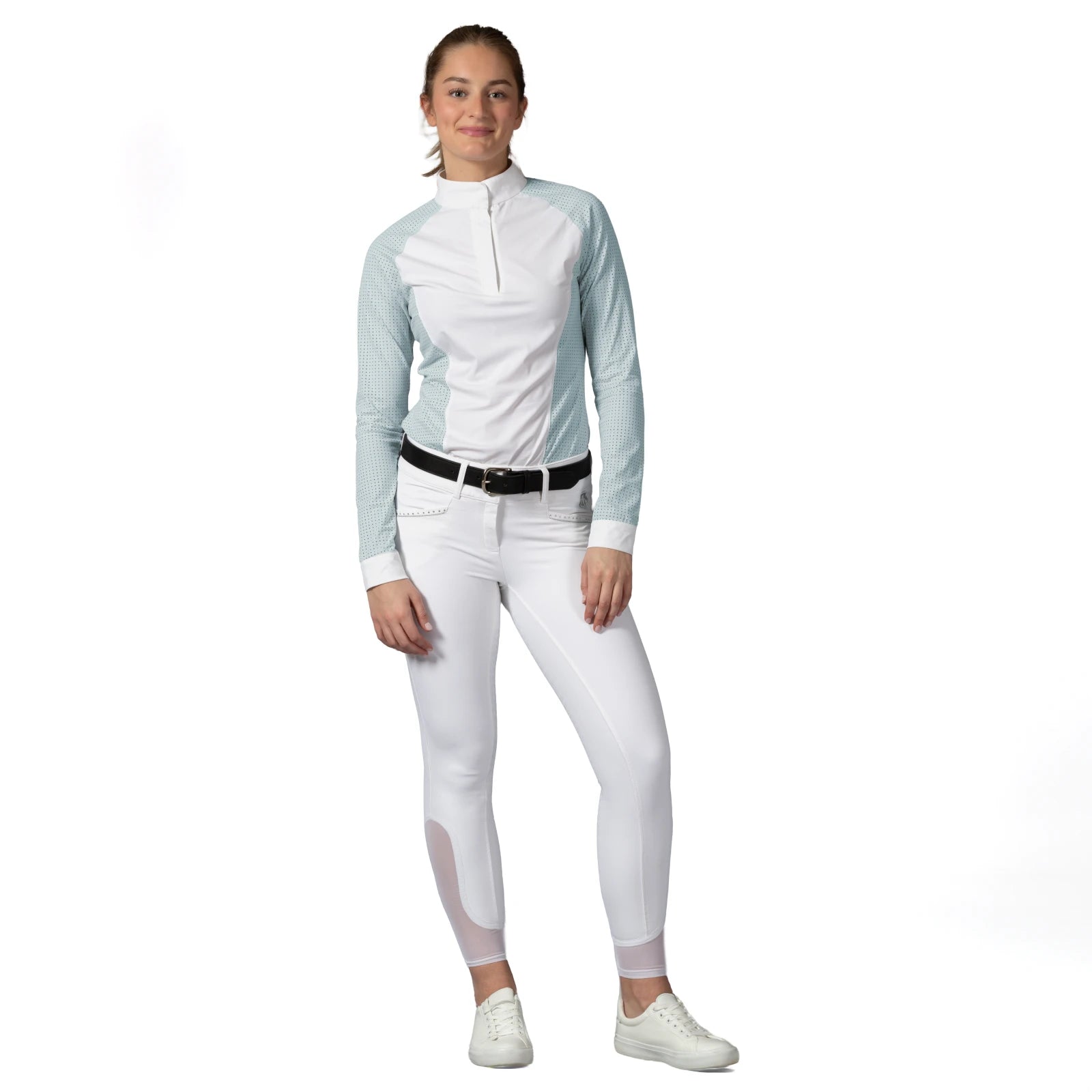 Full body view of a model wearing the white Equinavia Victoria Full Seat Breeches, show shirt, and white shoes on a white background