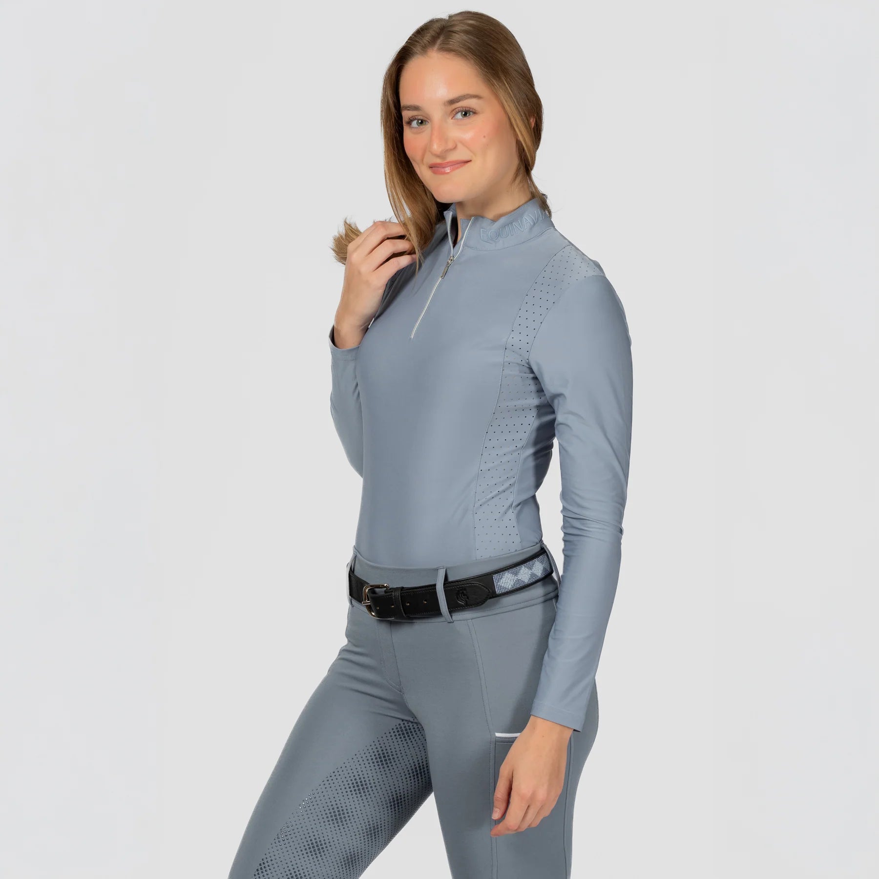 Angled front view of a model wearing Dusk Blue Equinavia Aurora Long Sleeve Training Shirt on a plain background