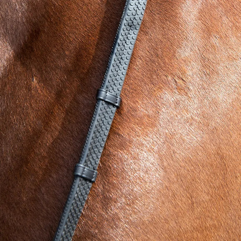 Close-up view of the pebble grip on the black Antares Signature Rubber Reins with Stops on a horse's neck