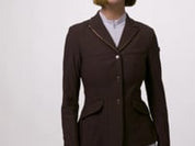 Video showing a female model posing while wearing the brown LeMieux Brilliance Diana Show Jacket on a plain background