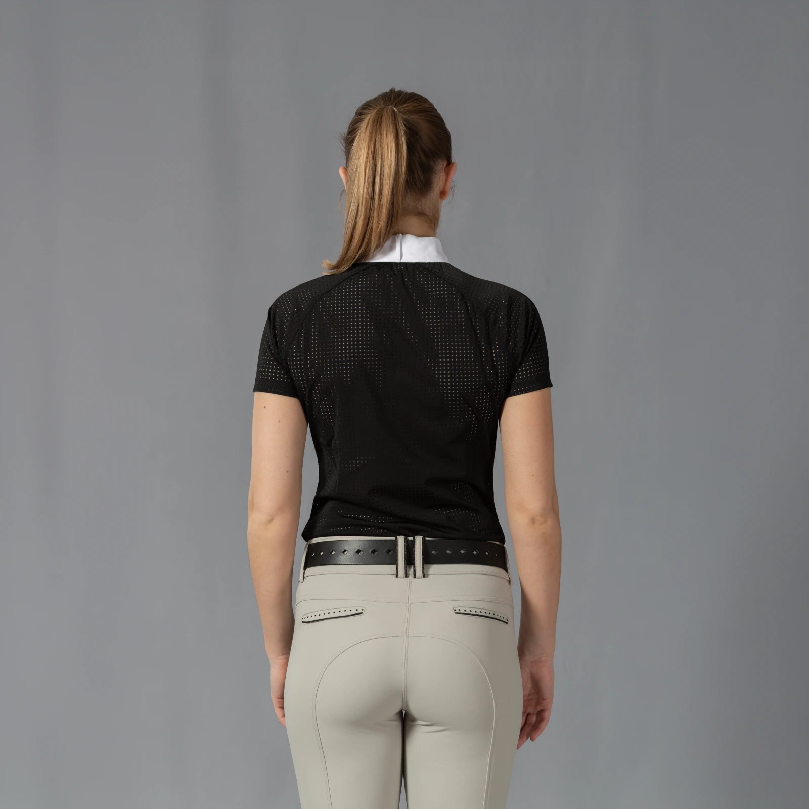 Back view of a model wearing the Equinavia Sara Womens Perforated Short Sleeved Show Shirt in black and white on a gray background